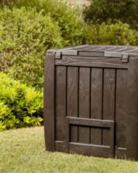 compostbak die op een houten kist lijkt in een tuin op het gras